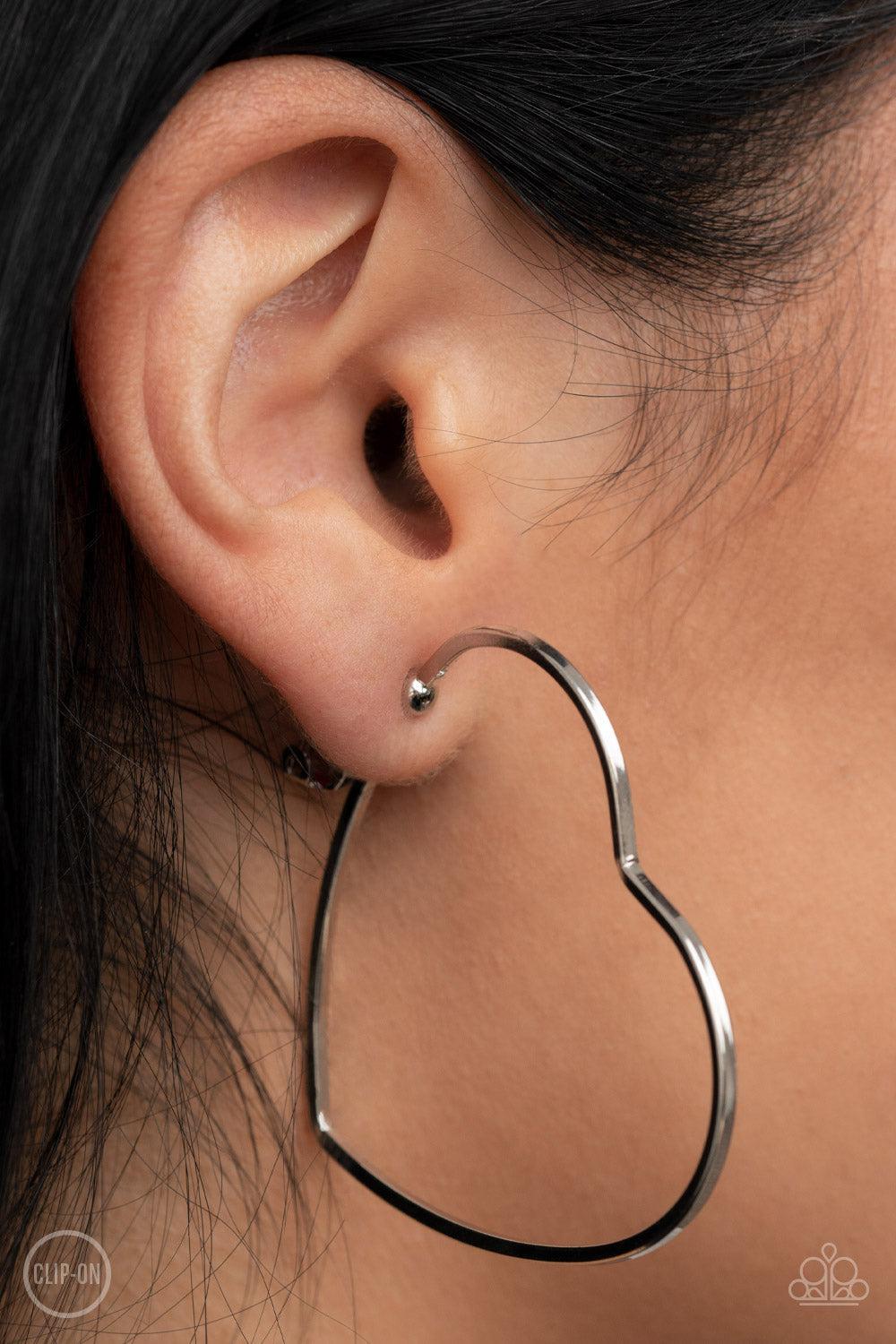 Harmonious Hearts Silver Clip-On Hoop Earrings - Paparazzi Accessories- on model - CarasShop.com - Paparazzi Jewelry by Cara Jewels